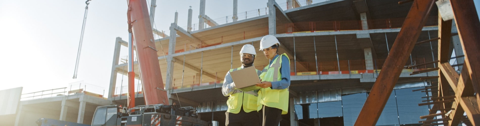 Two construction workers looking at project papers at worksite