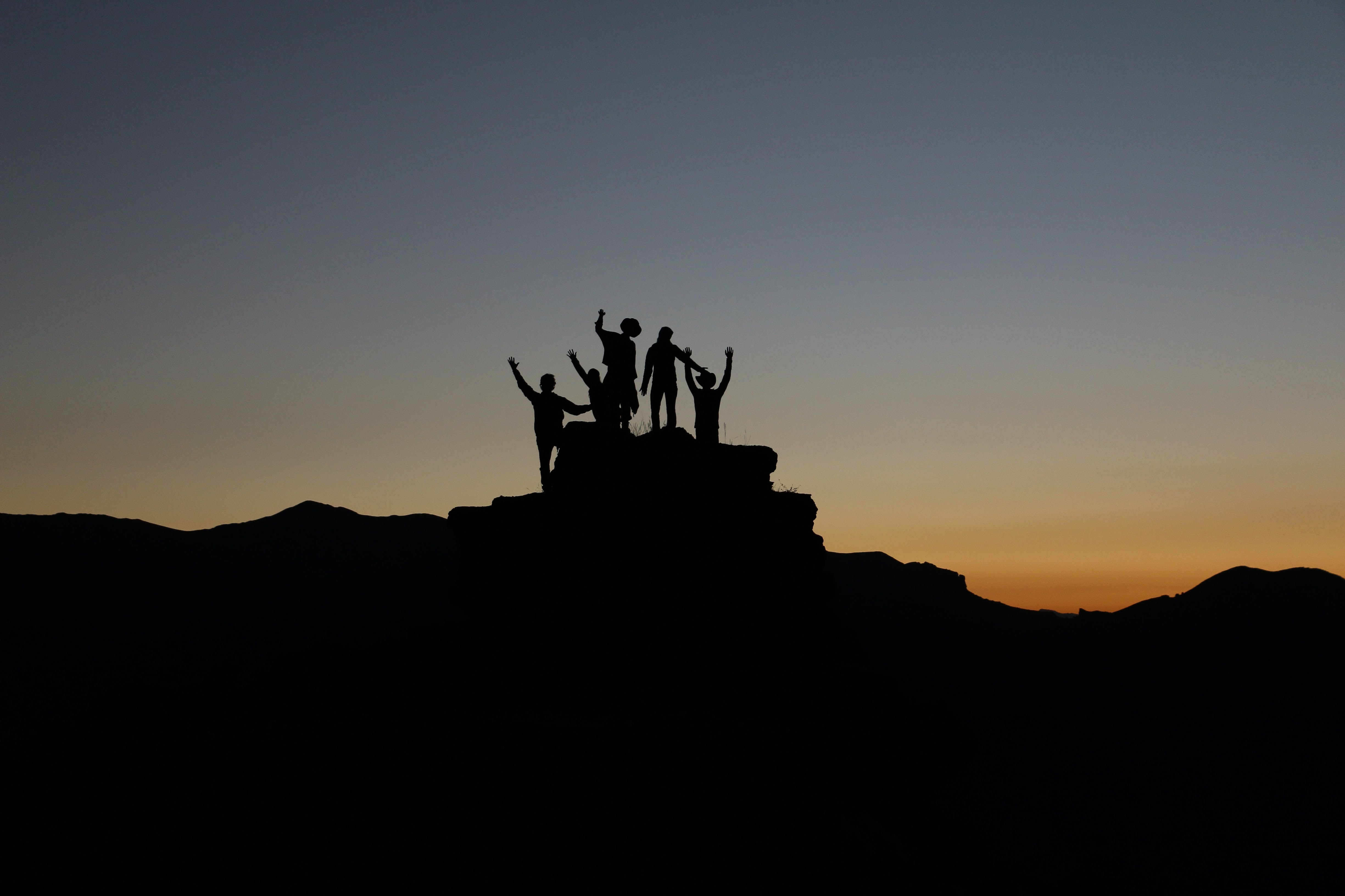 Team climbing mountain at dusk