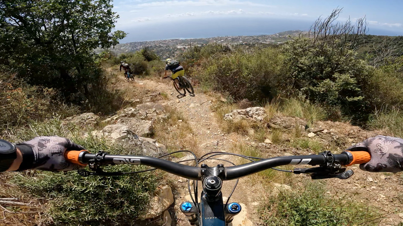 Three mountain bikers descending a rocky trail